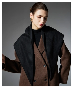 Detailed view of a black knit triangle shawl draped over a classic brown wool coat