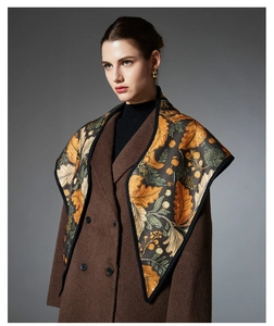 Detailed view of luxury vintage floral leaf print shawl draped over a brown wool coat