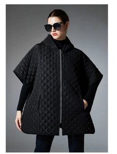 Close-up of black quilted poncho with diamond pattern, hood, and metal zipper detail