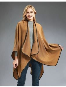 Close-up of camel knit shawl with black leather trim and soft texture detail
