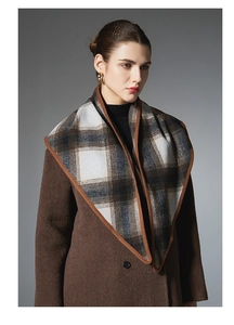 Detail of vintage brown plaid wool triangle shawl with thick hemmed edges for winter wear