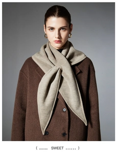 Detail of soft beige knit triangle scarf shawl styled with a brown winter wool coat