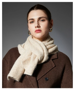 Close-up of beige chunky knit scarf showing soft wool texture and intricate weave detail