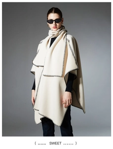 Detail of cream cape shawl with thick wool texture and black blanket stitch edge