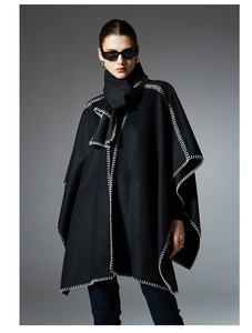 Detail of black wool cape coat with white whipstitch edges and matching scarf set