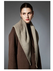 Detail of soft cashmere triangle scarf draped elegantly over a winter coat