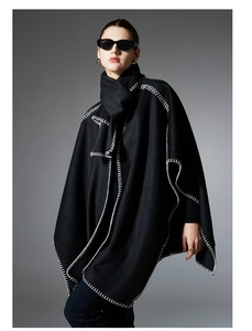 Detail of black wool shawl with white handmade whipstitch edges and premium texture