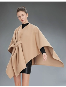 Detail of camel wool cape showing asymmetric drape and knotted design on a model