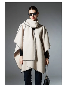 Close-up of beige shawl with hand-stitched black blanket stitch edges and wool texture