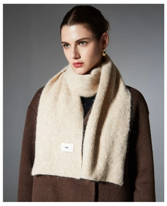 Detailed close-up of cream knit wool scarf featuring a ribbed texture and egg label