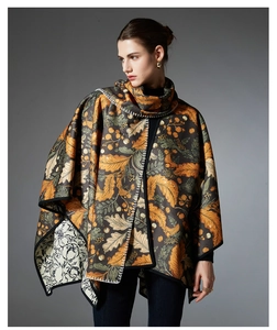 Detail of autumn-themed poncho featuring oak leaf prints and elegant white edge stitching