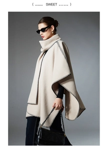 Detail of beige poncho shawl with black blanket stitch and thick woolen fabric texture