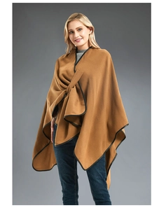 Close-up of brown wool shawl cape with premium black leather trim and draped front design