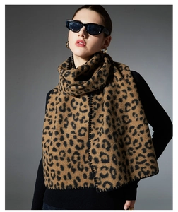 Detailed view of leopard print scarf with premium hand-stitched black blanket edges