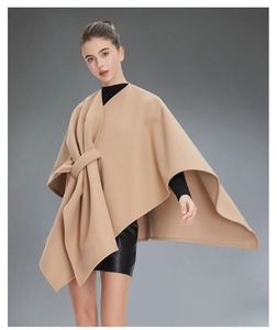 Detail of camel wool poncho jacket featuring elegant front knot drape and layered silhouette