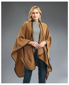 Detail showing caramel knitted shawl with black leather trim edge and crossover clasp