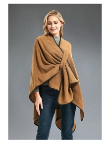 Detail of knit poncho wrap featuring a leather trim edge and cross buckle closure