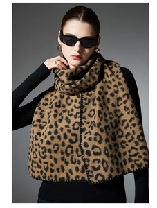 Detailed view of leopard print scarf with black whipped stitch edges and thick texture