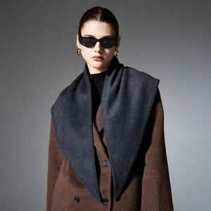 Minimalist dark grey triangular scarf wrap worn over a brown wool coat in a premium style