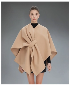 Detail of elegant camel sleeveless cape with a stylish oversized knot design on front