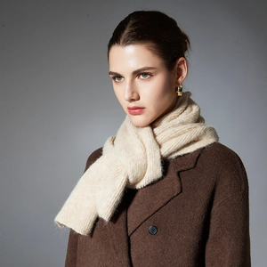 Beige chunky knit scarf with ribbed texture styled on a model with a wool coat