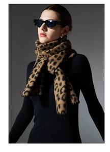 Detailed view of women's leopard print winter scarf with delicate scalloped edges