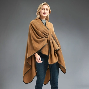 Women's camel poncho with black leather trim and elegant cross-knot knit design
