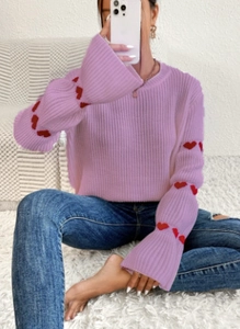 Détail du pull en maille lilas avec broderies de cœurs rouges sur les manches longues