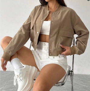 Close-up of khaki baseball jacket featuring ribbed collar and metallic snap buttons