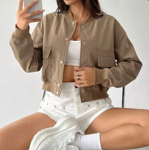 Close-up of khaki cropped baseball jacket with large pockets and metal snap buttons