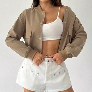 Close-up of khaki cropped bomber jacket with snap buttons and large flap pockets