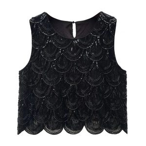 Close-up of black sleeveless top with heavy beadwork and scalloped sequin patterns