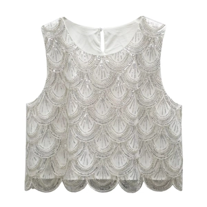 Detailed view of silver sequins and scalloped hem on white sleeveless lace top