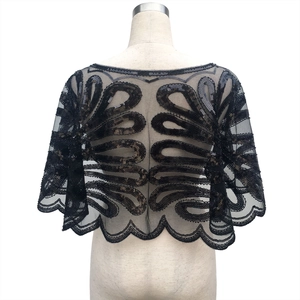 Détail de la broderie à paillettes sur tulle noir et bordure ondulée du châle