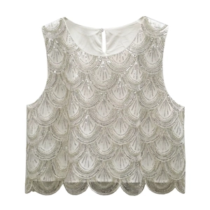 Detailed close-up of intricate silver sequins and beadwork on a white sleeveless top