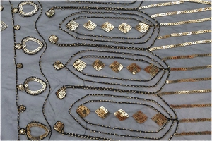 Détail d'un châle vintage 1920 avec paillettes dorées et broderie en tulle noir