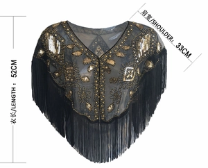 Detail of vintage black mesh shawl with gold sequins floral patterns and long fringe