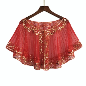 Detail of red mesh cape with golden sequin floral patterns and elegant embroidery