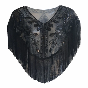 Detail of black mesh shawl featuring V-neckline, floral embroidery, sequins, and long fringe