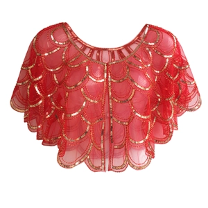 Detail of red mesh shawl with golden wave-pattern sequins for vintage evening wear