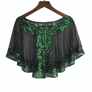 Close-up of vintage 1920s style black mesh shawl with green sequins and gold beading detail