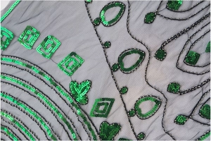 Vue macro de paillettes vertes et de perles complexes sur un tissu en maille noire