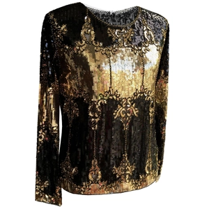 Close-up of intricate gold sequin embroidery and floral patterns on black party top