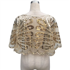 Vue détaillée du dos d'une cape en mesh à paillettes dorées avec des motifs vintage ornés