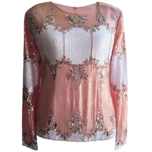 Detailed view of pink and white sequins embroidery with floral patterns on a long sleeve top