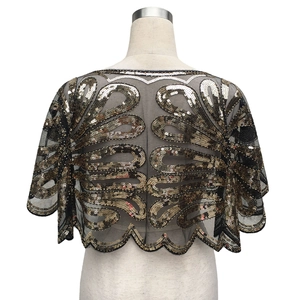 Détail de broderie de paillettes vintage sur cape en maille noire avec motifs de plumes