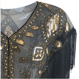 Detailed view of 1920s vintage black mesh shawl with gold sequins and fringe