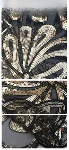Gros plan de paillettes dorées et broderie de dentelle sur tissu en maille noire