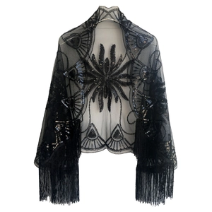 Detail of black evening shawl featuring sequins embroidery, floral mesh, and long fringe