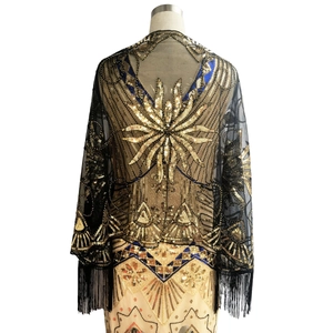 Close-up of vintage black mesh shawl with gold sequins, beadwork and tassel fringe